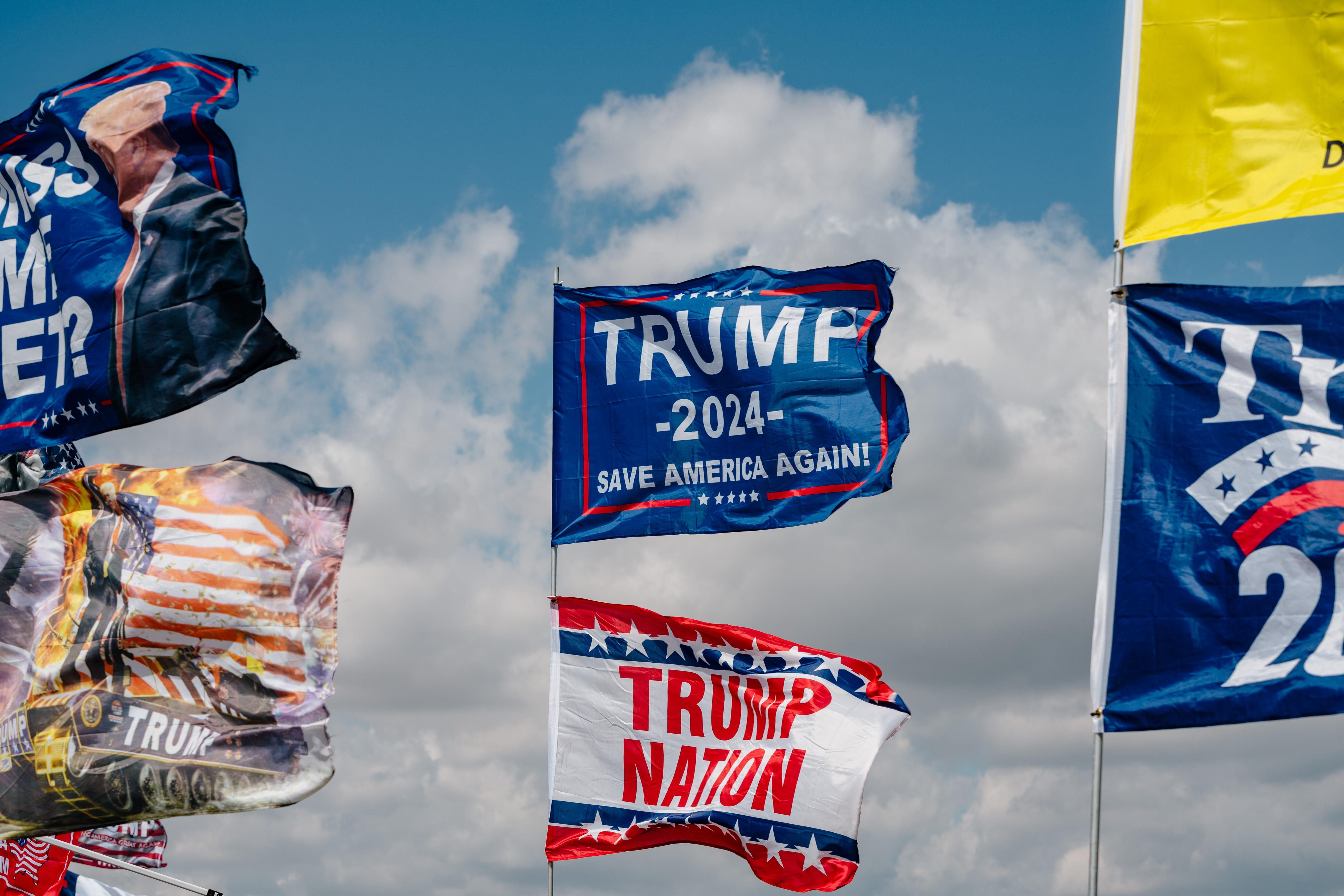 Banderas ondean sobre una tienda de campaña cerca de la entrada de un mitin de campaña de Donald Trump en Freeland, Michigan, EE.UU., el 1 de mayo de 2024. EFE/NICK HAGEN
