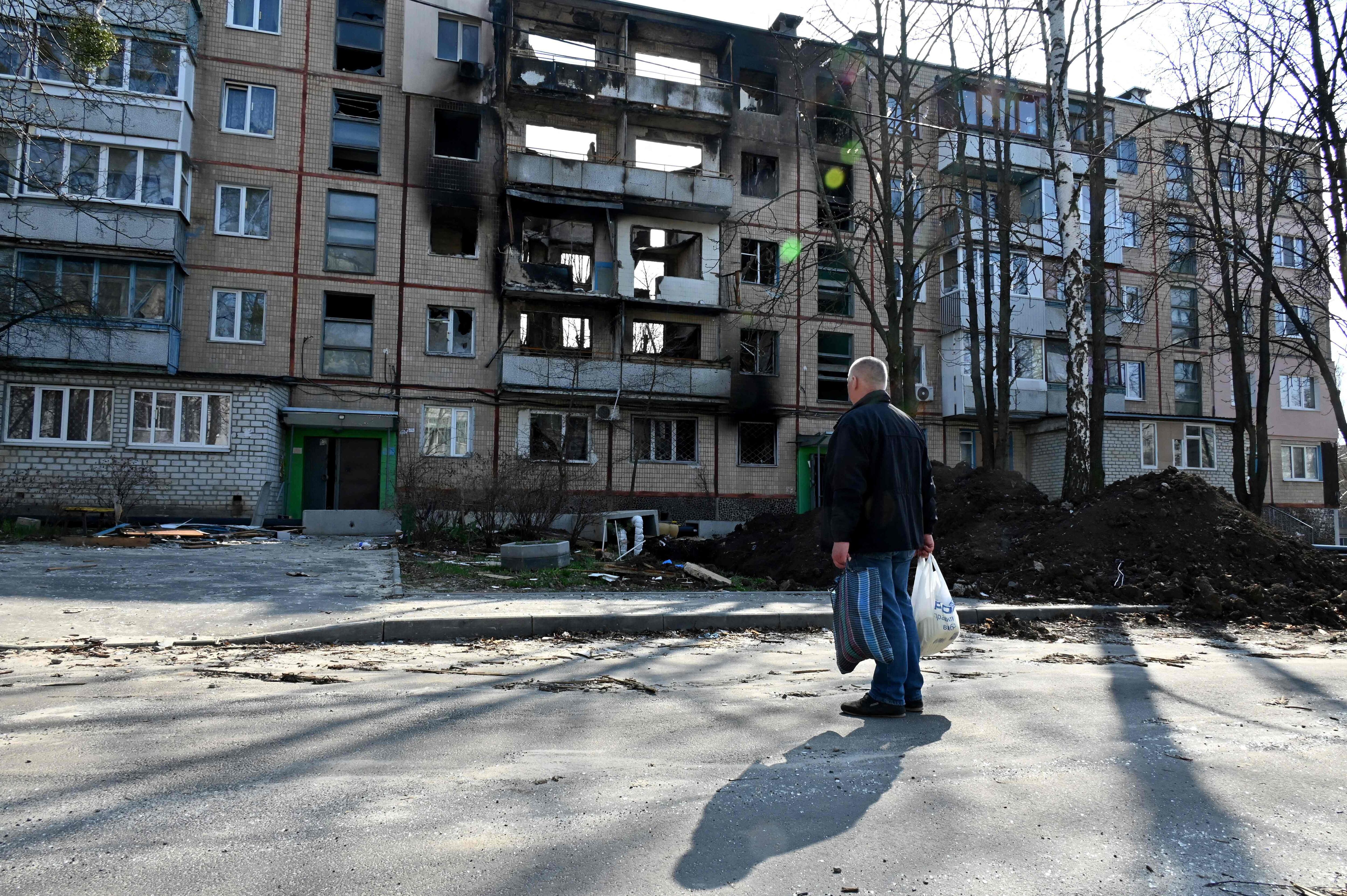 Un hombre mira un edificio residencial de cinco pisos destruido, en la segunda gran ciudad ucraniana de Kharkiv, el 10 de abril de 2022.