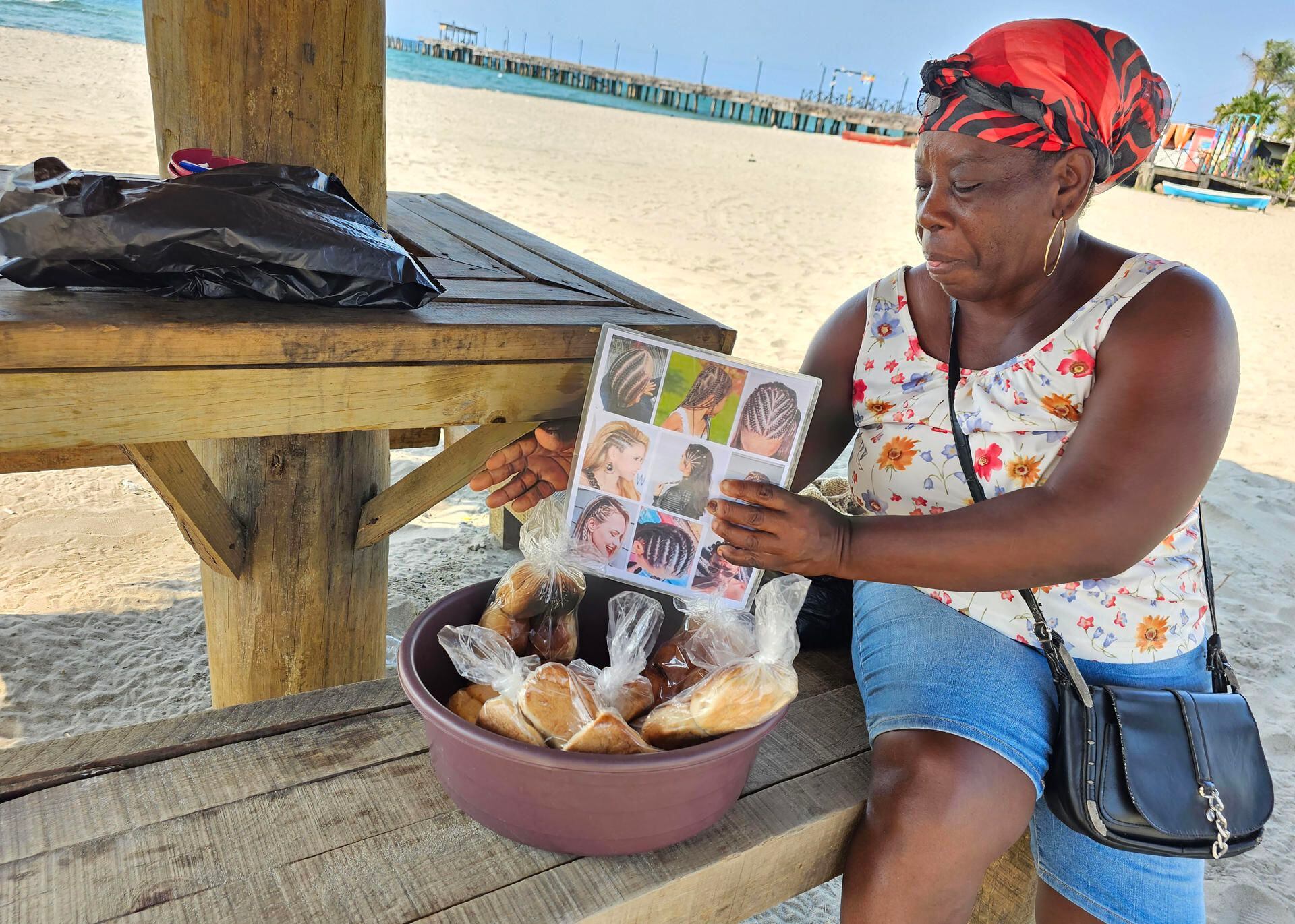 Viviana, miembro de la comunidad garifuna hondureña, ofrece en venta "Pan de Coco" y Trenzas a los turistas que visitan las playas,  en la ciudad de Tela (Honduras). EFE/ José Valle