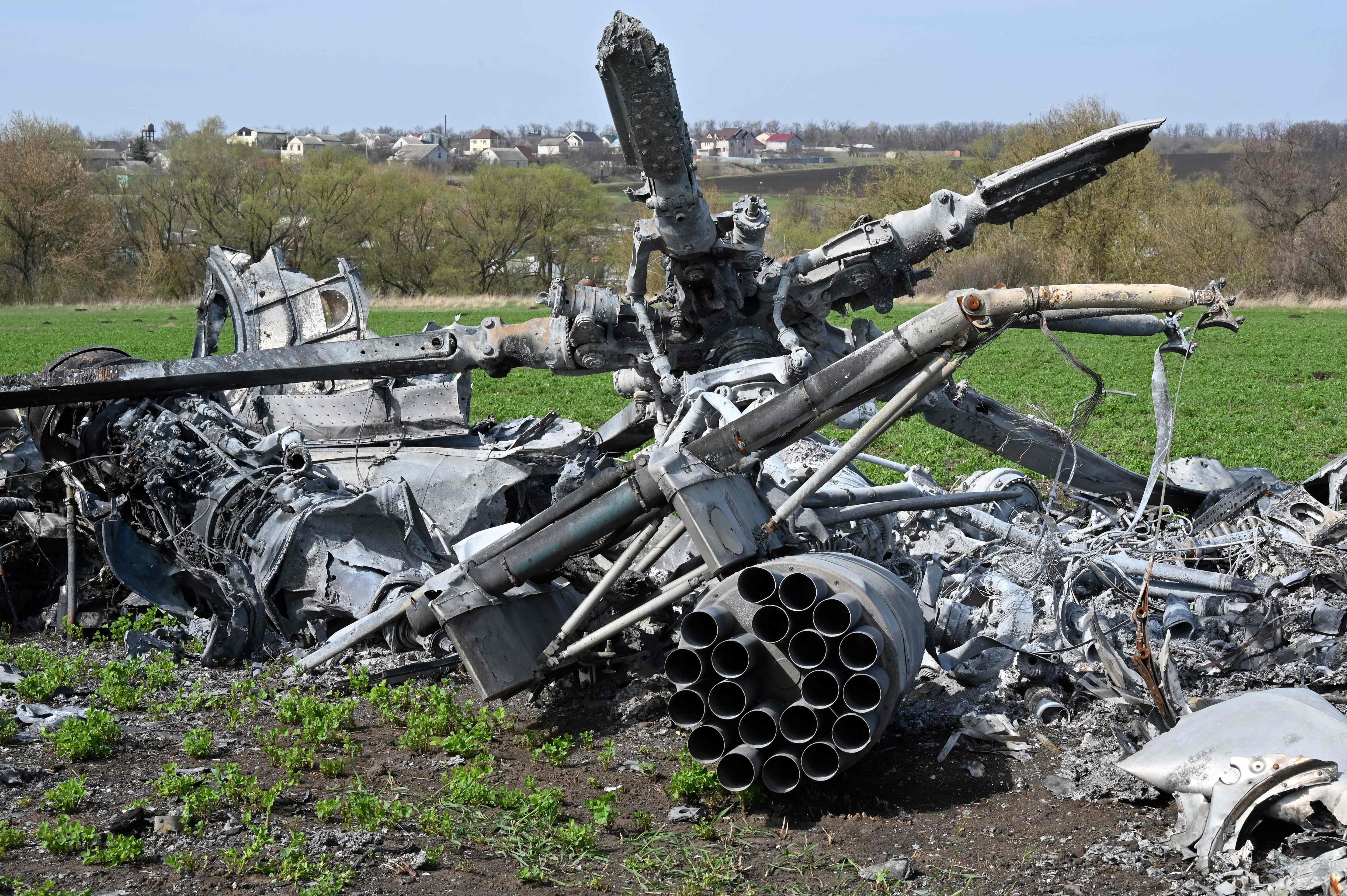The wreckage of a downed Russian helicopter lies in a field near Kharkiv on April 16, 2022, amid the Russian invasion of Ukraine. - Russia has stepped up air strikes on Kyiv, hitting another military factory a day after Moscow warned it would renew attacks following two weeks of relative calm in the Ukrainian capital. (Photo by SERGEY BOBOK / AFP)