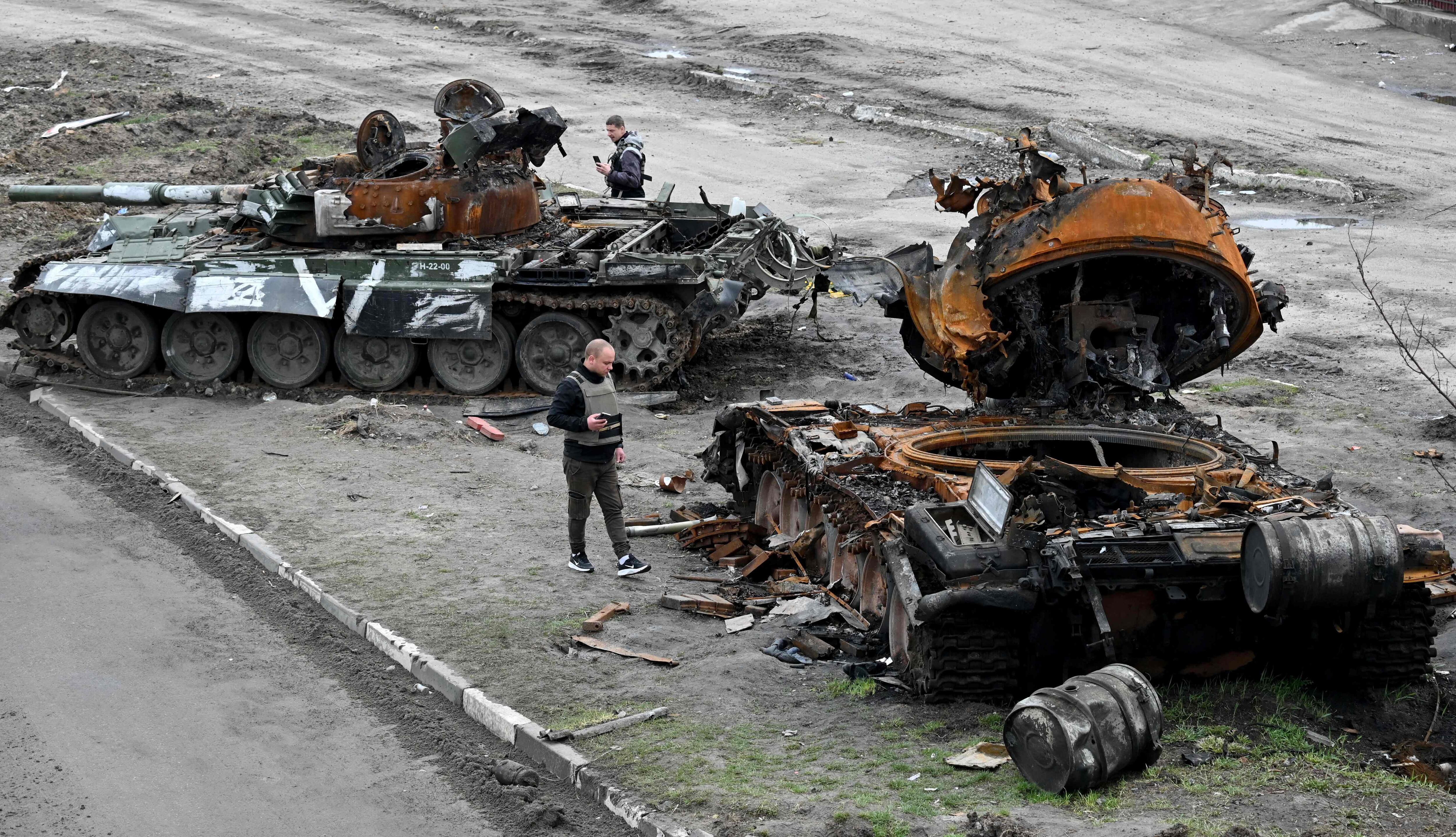 Residentes observan tanques rusos destruidos en las afueras de la aldea de Buzova, al oeste de Kiev, el 10 de abril de 2022