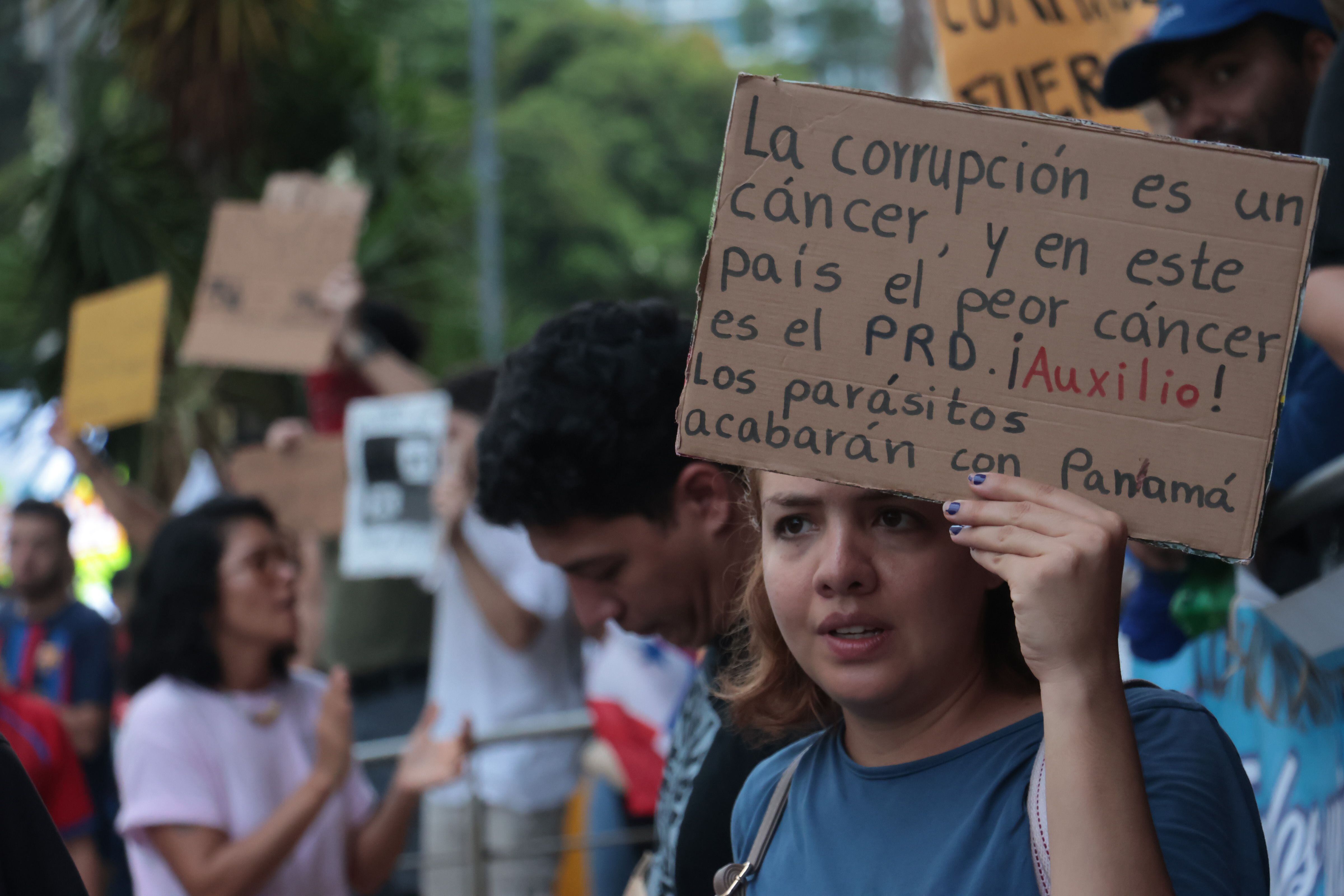 Varias personas protestaron para exigir información completa sobre la entrega de los llamados "auxilios económicos" educativos, el pasado 10 de abril, en una manifestación que se llevó a cabo frente a la Contraloría General de la República, en la avenida Balboa. EFE/ Gabriel Rodríguez
