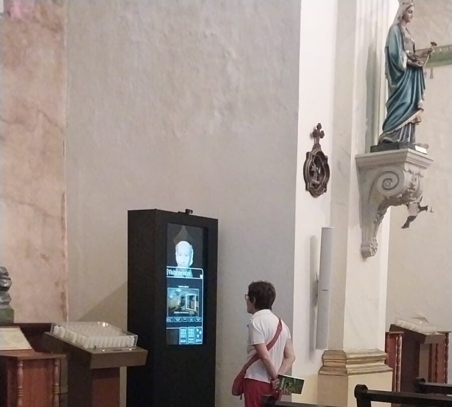 Una visitante, interactúa con el asistente virtual en el Oratorio San Felipe Neri. Cortesía.