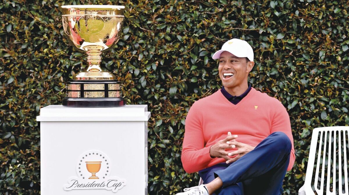 Tiger Woods observa la Copa que se llevará el equipo ganador del torneo. AFP