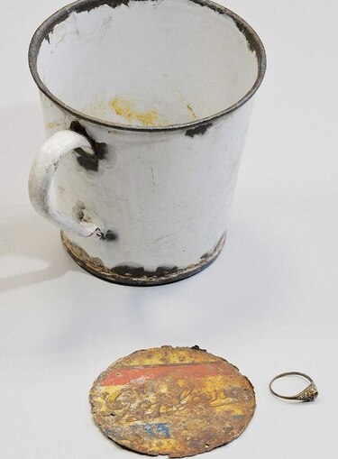 Hallan anillo y cadena de oro ocultas en taza en Auschwitz