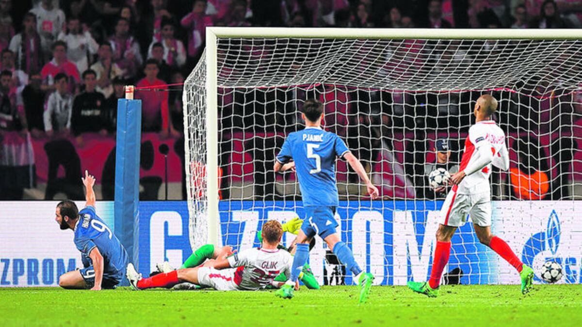 Gonzalo Higuaín (Izq.) consigue llegar al segundo palo para rematar a gol un pase como con la mano de Dani Alves, en el 2-0 de Juventus en Mónaco.