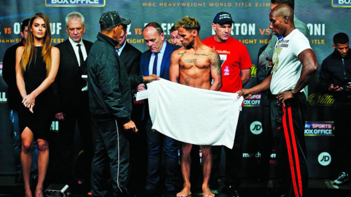 El boxeador panameño observa la báscula al momento de su pesaje en Inglaterra.