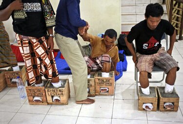 Campesinos indonesios protestan con zapatos de cemento