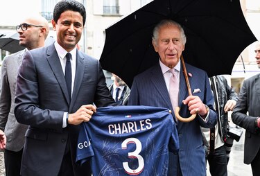 Carlos III recibe una camiseta del PSG de manos de Al Khelaifi