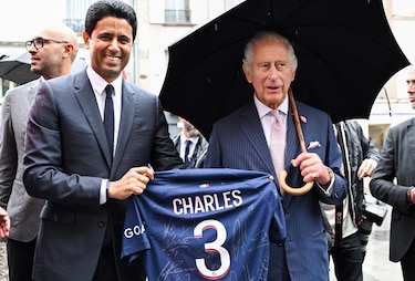 Carlos III recibe una camiseta del PSG de manos de Al Khelaifi