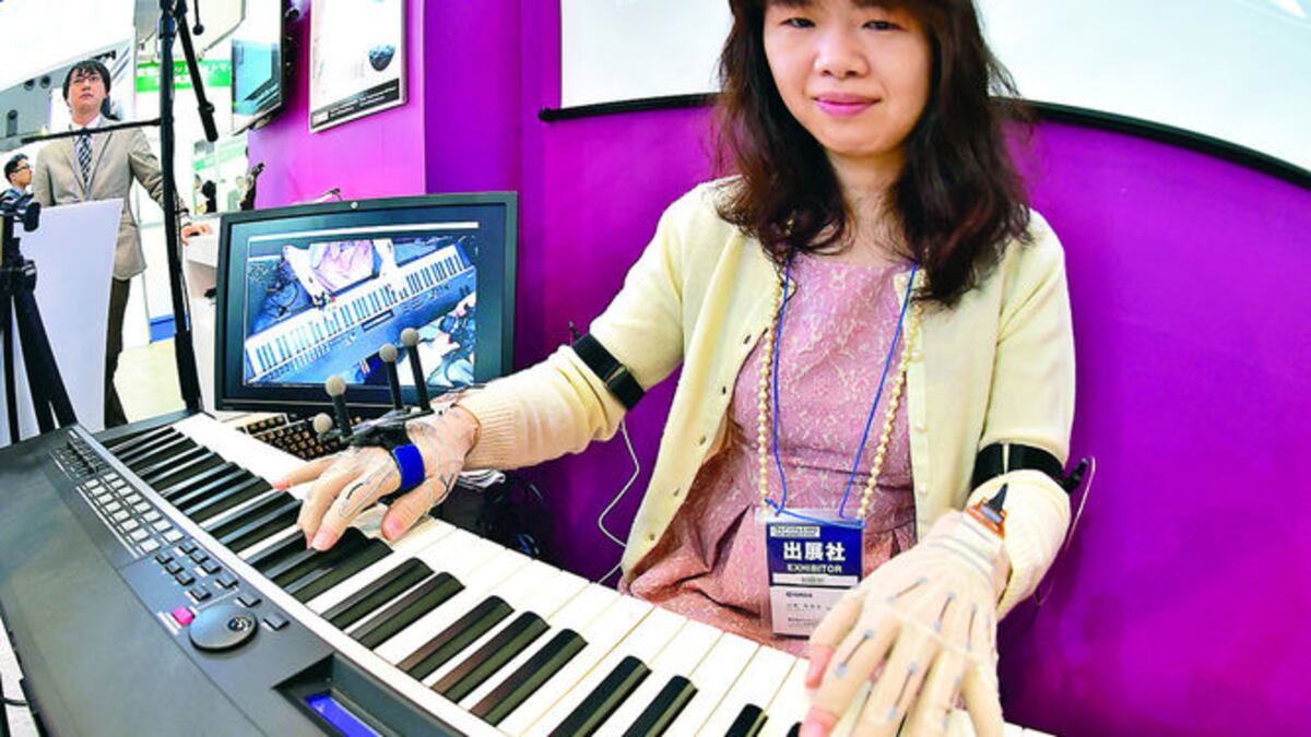 Un pianista toca el teclado mientras usa guantes especiales con sensores que graban los movimientos de sus dedos.