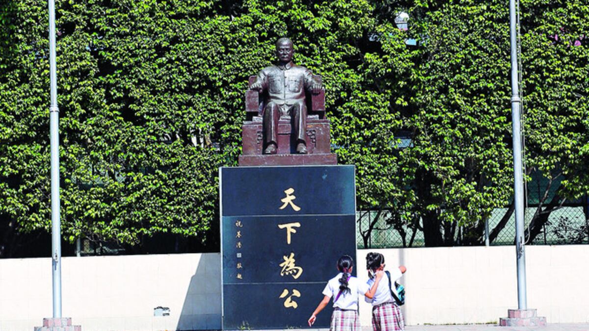 (1) En el patio central del plantel, dos estudiantes se acercan al monumento a Sun Yat Sen. (2) El uniforme escolar se modificará a partir de 20