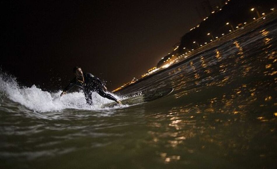 Surfistas nocturnos corren olas en playa de Lima