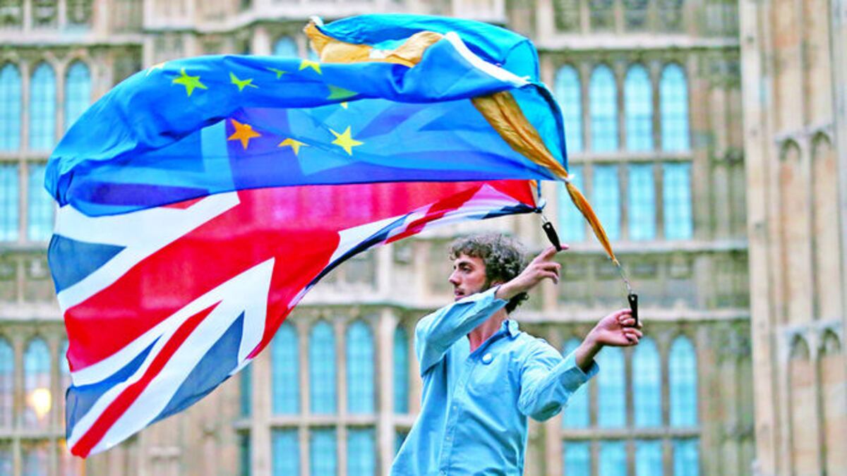 Un hombre ondea las banderas de Gran Bretaña y de la Unión Europea frente a la sede del Parlamento británico. Las protestas por el resultado del referéndum sobre la salida británic