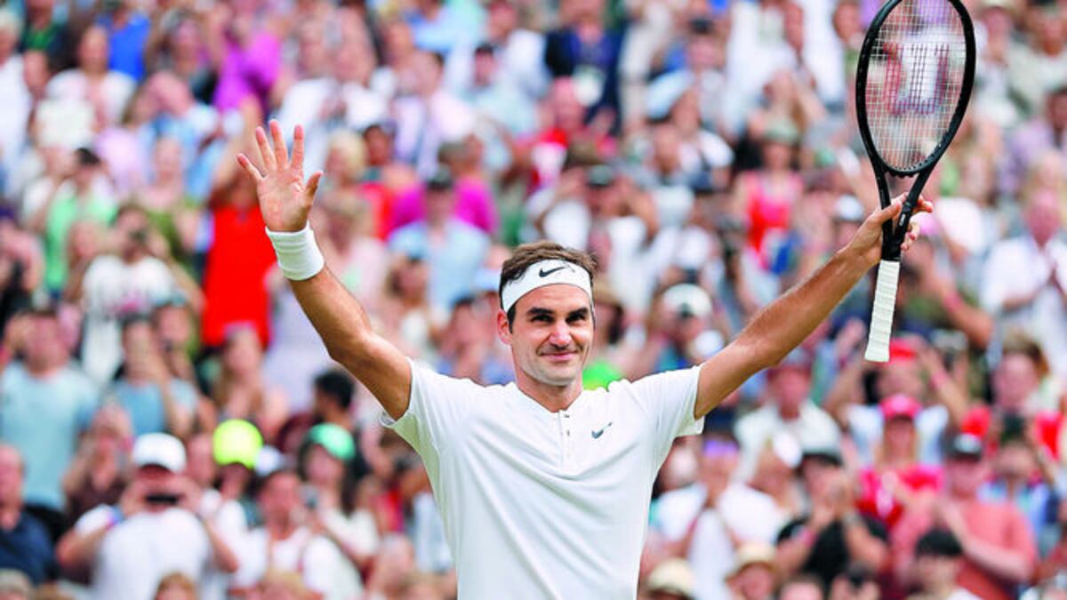 Roger Federer levanta los brazos en señal de triunfo.