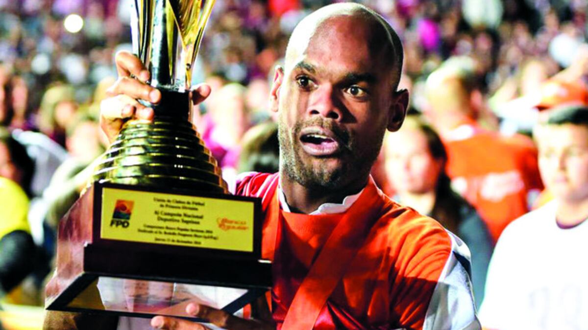 Adolfo Machado (izq.) y Rolando Blackburn posan con la copa de campeón.