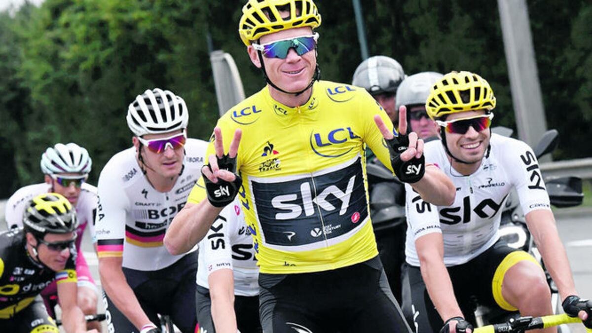 El británico Chris Froome levanta los cuatro dedos en señal de sus títulos.