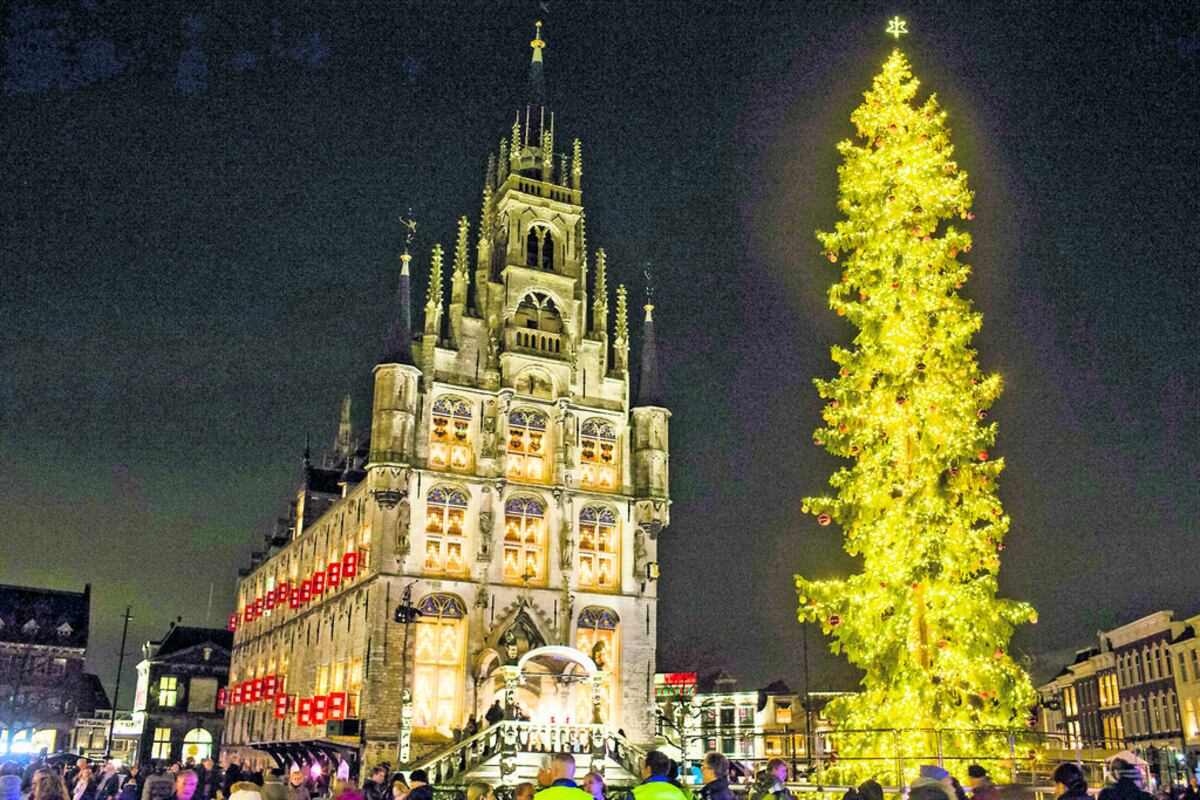 El árbol se enciende en la plaza central en Gouda, Holanda, así como cientos de velas dan luz detrás de las ventanas del ayuntamiento.