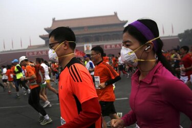 Contaminación en Beijing obliga a miles de maratonistas a correr con máscaras