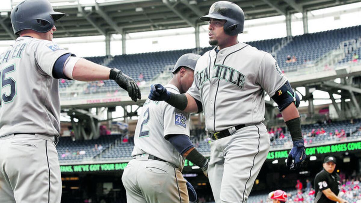 Nelson Cruz (Der.) celebra con sus compañeros de equipo tras una de las anotaciones.
