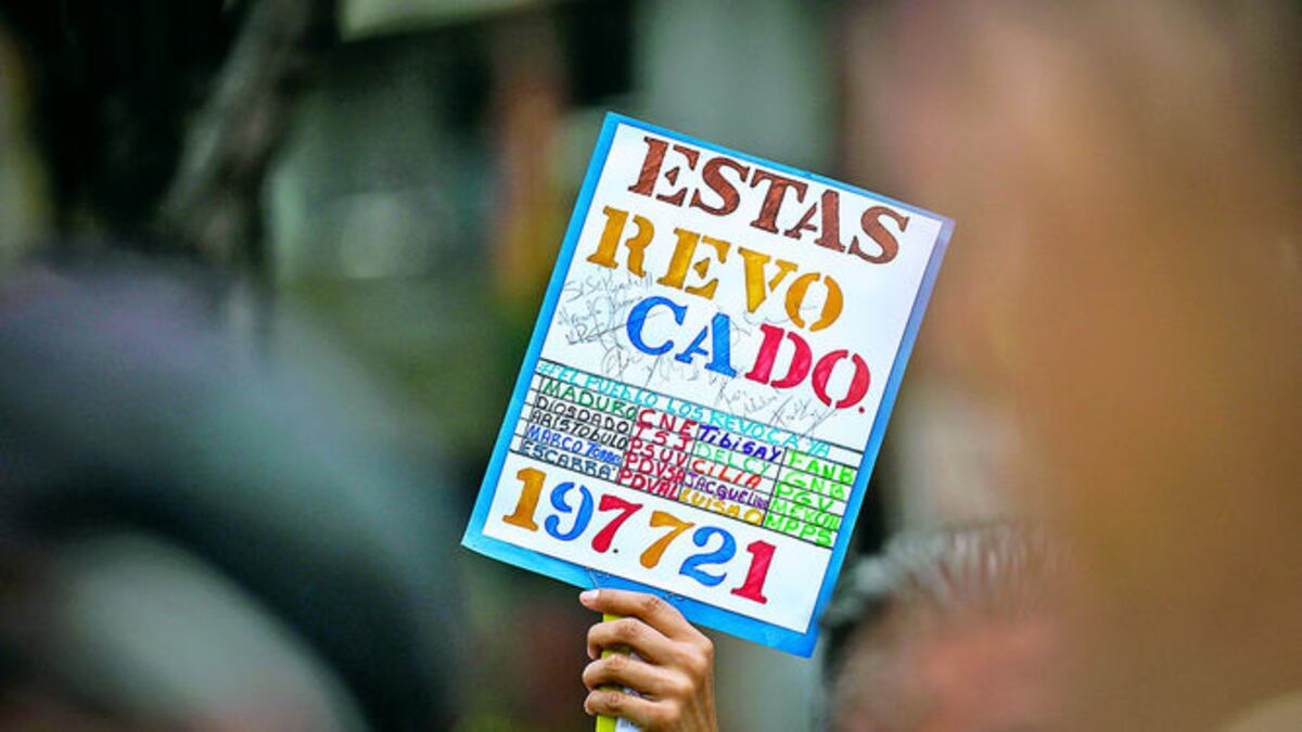Un manifestante en Caracas agita un cartel alusivo a la intención opositora de lograr la salida del poder de Nicolás Maduro a través de una consulta popular.