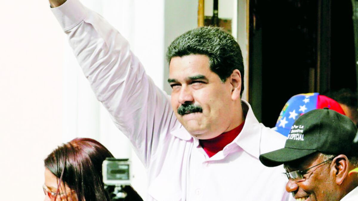 Nicolás Maduro saluda a seguidores en el Palacio de Miraflores. Junto a él, su esposa, la diputada Cilia Flores (Izq.), y su vicepresidente, Aristóbulo Isturiz (Der.).