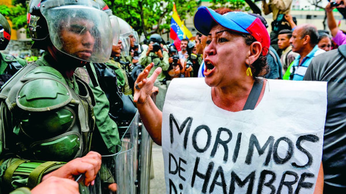 Ciudadanos portaban pancartas que ilustraban la situación desesperada por la que atraviesa el país sudamericano, mientras las fuerzas policiales les bloqueaban el acceso al Consejo Naciona