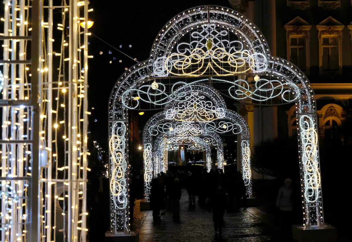 Personas caminan frente a motivos navideños para las celebraciones de Año Nuevo y Navidad, en San Petersburgo, Rusia. EFE