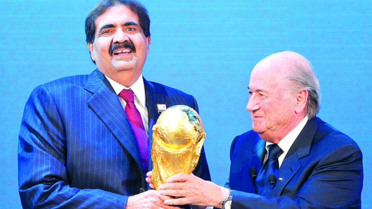 El jeque Hamad bin Khalifa Al-Thani, emir de Catar (Izq.), recibe el trofeo de la Copa Mundial por parte del presidente de la FIFA, Joseph Blatter, el 2 de diciembre de 2