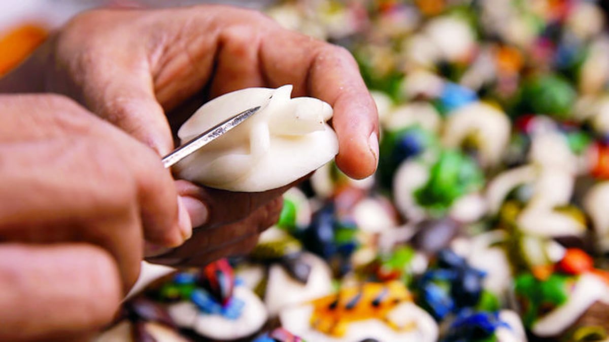 Una tortuga sobre una piedra confeccionada a base de tagua (semilla de una palma) es tallada por el artesano para luego darle el toque de pintura.