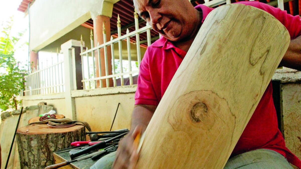Las manos del artesano Miguel Antonio Ávila lijan la madera que pronto se convertirá en un repicador, o en un pujador, que alegrará alguna festividad pueblerina, o servirá de adorno en u
