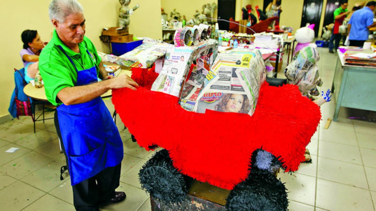 Edwin Sánchez usa todo su ingenio para decorar lo que será un lindo carro. La piñatas más fáciles de hacer son las pelotas.