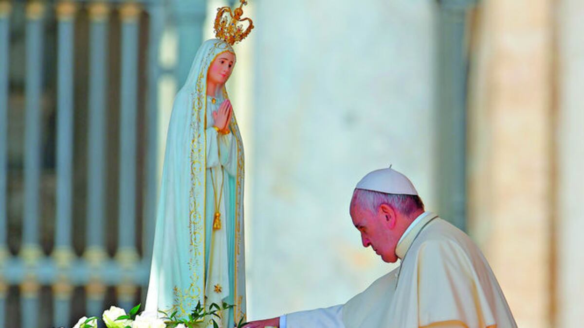 El papa Francisco toca una imagen de Nuestra Señora de Fátima mientras llega a una audiencia general en la plaza de San Pedro, el 13 de mayo de 2015 en el Vaticano.