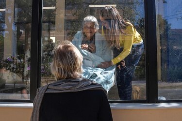 Postales de un hospital confinado: madre e hija separadas por un vidrio