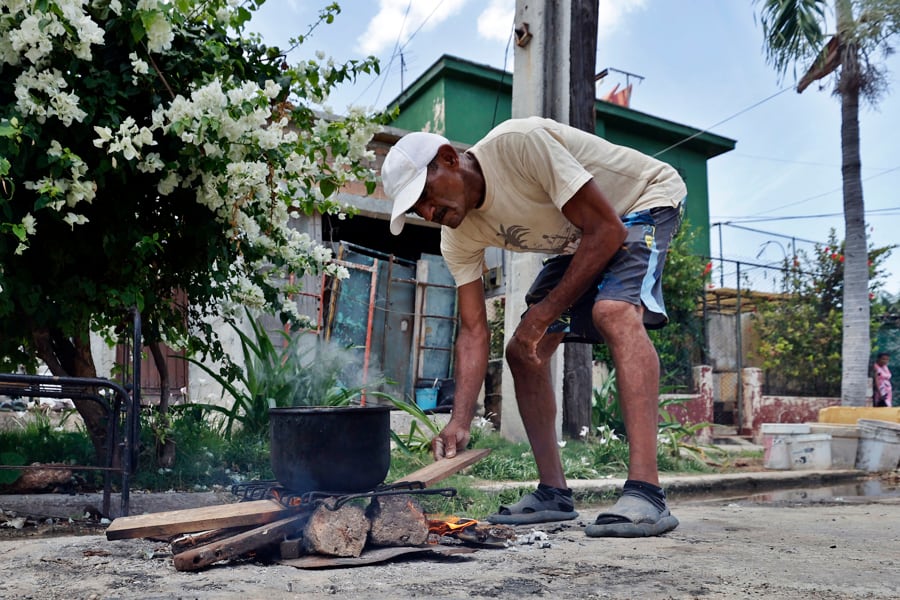 Fotografía de una persona cocinando en una calle en La Habana (Cuba). EFE/Ernesto Mastrascusa