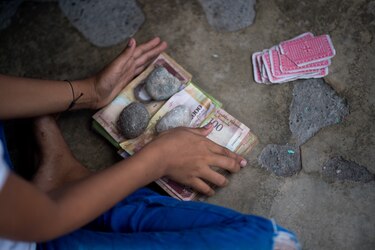 Billetes en desuso son el juguete de los niños en un pueblo de Venezuela