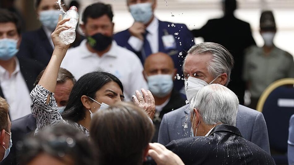Una mujer lanza agua al presidente chileno Piñera en un acto en La Moneda