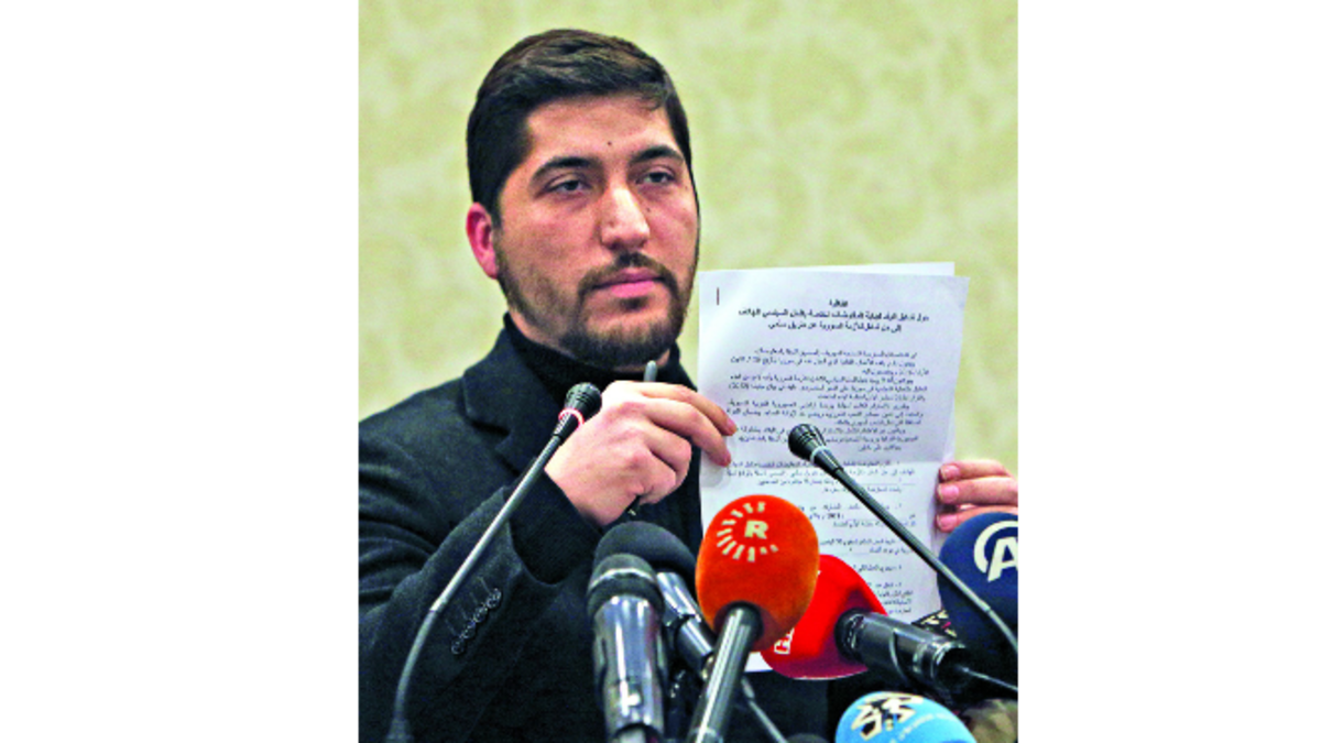 Un representante de la coalición opositora favorable al diálogo muestra el pacto, mientras que un grupo kurdo afirma que no acepta las conversaciones.