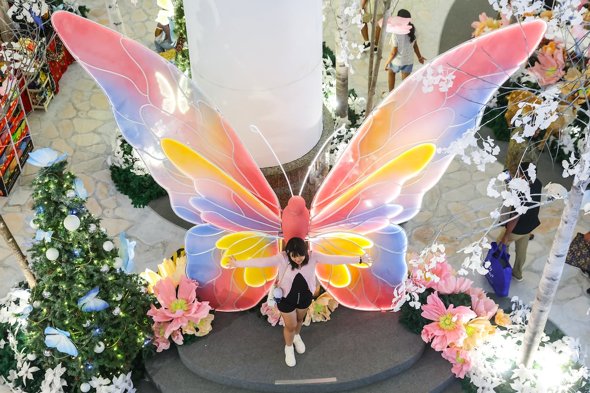 Una mujer posa para una foto junto a las decoraciones navideñas exhibidas antes de las celebraciones navideñas en Kuala Lumpur, Malasia. EFE