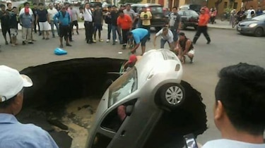 Video: Socavón 'se traga' a auto con familia adentro en Perú; transeúntes los rescatan