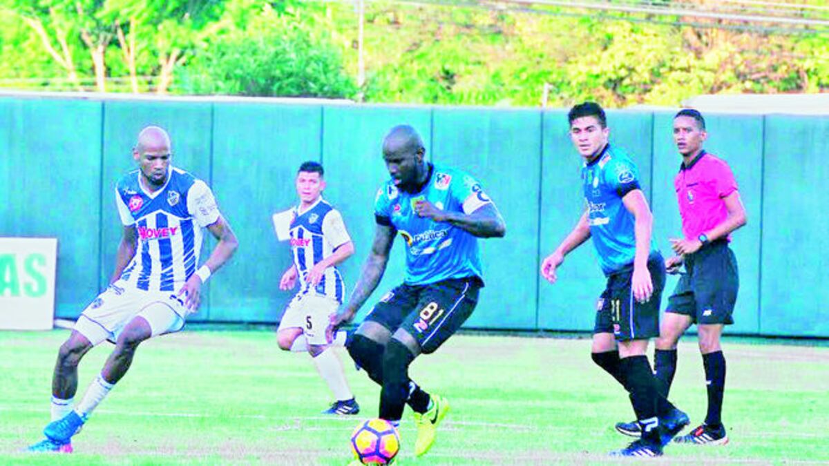 Felipe Baloy, con el balón, es seguido de cerca por Humberto Ward (Izq.), los dos goleadores del partido en Santiago.