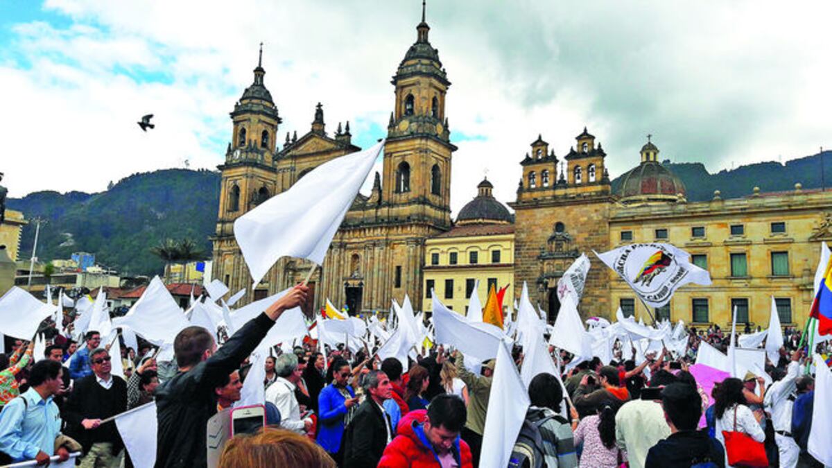 La gente, con banderas blancas, celebra en la Plaza de Bolívar