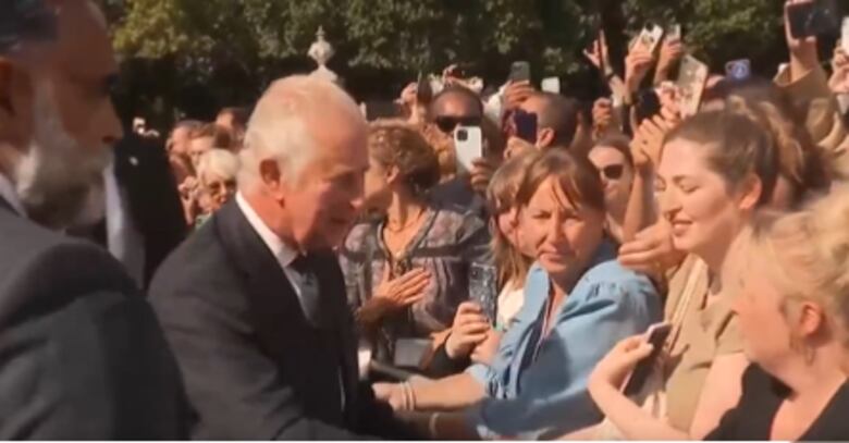 Carlos III muestra una imagen cercana al saludar a admiradores en Buckingham