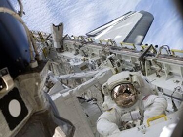 Astronautas trabajan con brazo robot