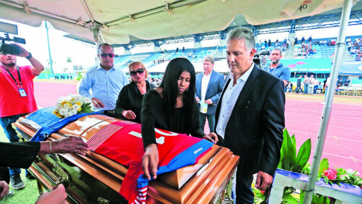 Gixiani, esposa de Amílcar, coloca la camiseta número 21 de la selección nacional sobre el ataúd.