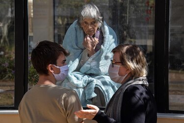 Postales de un hospital confinado: madre e hija separadas por un vidrio