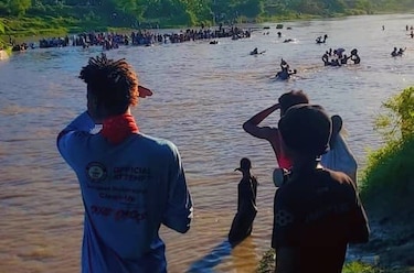 Haitianos cruzan un río para escapar de ataque de pandilla en el centro del país