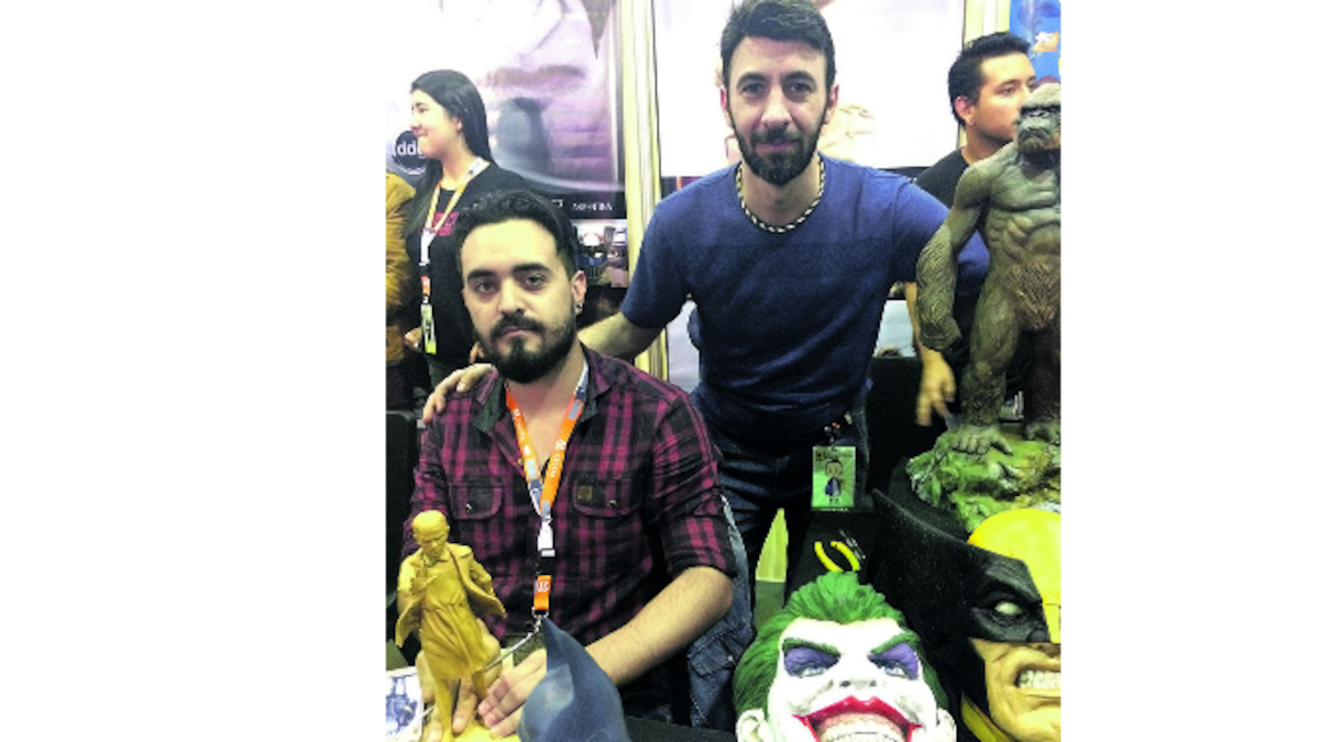 De pie, Diego González, junto a su compañero de DDG, Emiliano Calderón, y algunos de sus trabajos expuestos en el Comic Con Colombia.