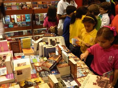 Niños y adultos visitan la feria del libro antes de su inauguración