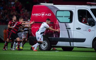 Futbolistas brasileños empujan una ambulancia averiada en la cancha